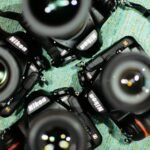 four black Nikon DSLR cameras on green textile